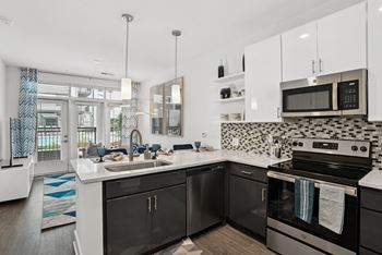 a kitchen with black and white appliances and a sink at Link Apartments® Mint Street, North Carolina